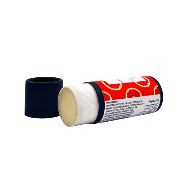 Vegan lip balm in grapefruit and cocoa butter, shown in biodegradable packaging with lid off