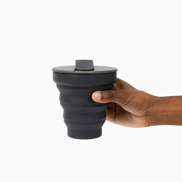 Collapsible cup shown up in a hand, charcoal colour