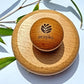 Wooden body brush with 'ecojiko' branding on a light background with leaves.