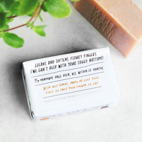 Paper Plane baker's soap showing back of paper wrapper, reads "Cleans and softens floury fingers (we can't help with your soggy bottom), 95g minimum, use within 12 months, With wet hands, apply all over then rinse to smell good enough to eat"