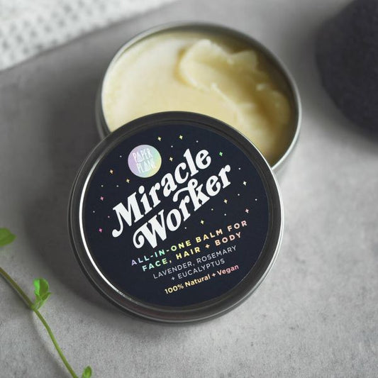 Miracle worker balm in tin packaging with lid off showing contents inside