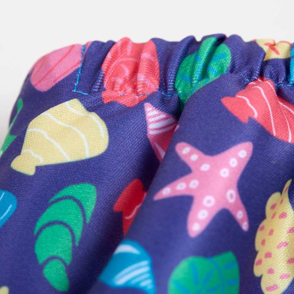 Reusable swim nappy close up view of elastic waist, in Mussel Seashells design (dark blue background with colourful star fish, mussels and shells)