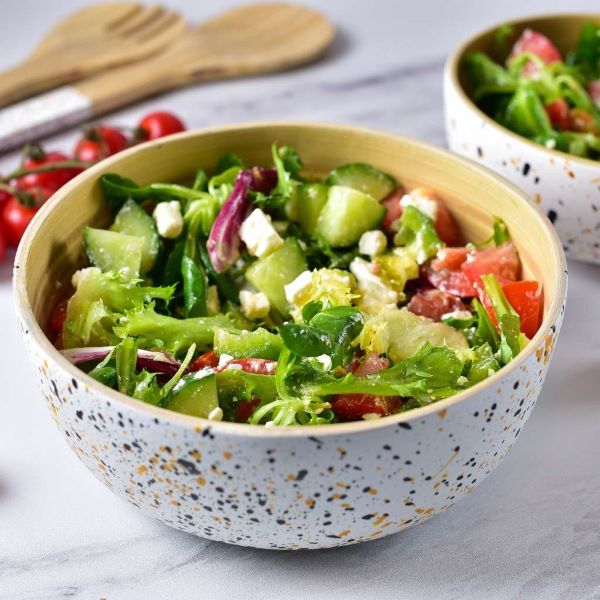 Bamboo serving bowl with salad in white (white with coloured speckles on outside, bamboo inside)