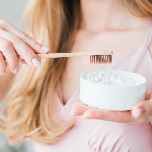 Bamboo toothbrush in use with toothpaste powder