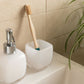 Bamboo toothbrush on bathroom sink in glass pot