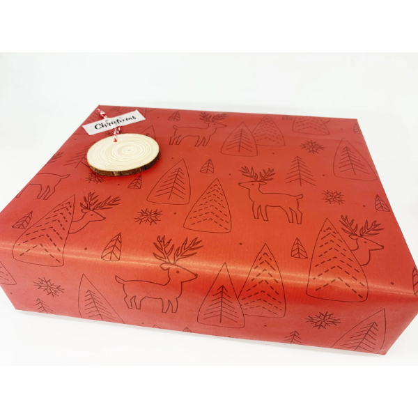 Eco-friendly Christmas wrapping paper Red with reindeer and trees in black outlines wrapping a parcel