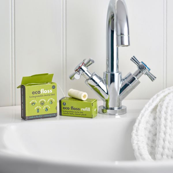 Eco-friendly vegan dental floss and refill pack at bathroom sink