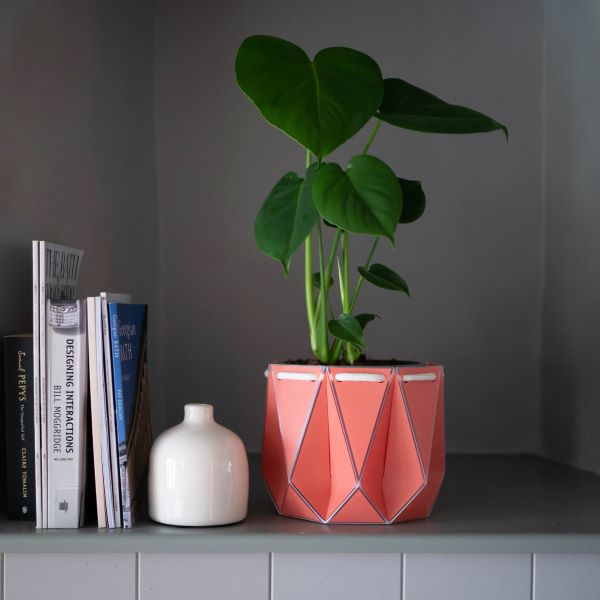 POTR self watering plant pot large in coral on shelf with plant inside