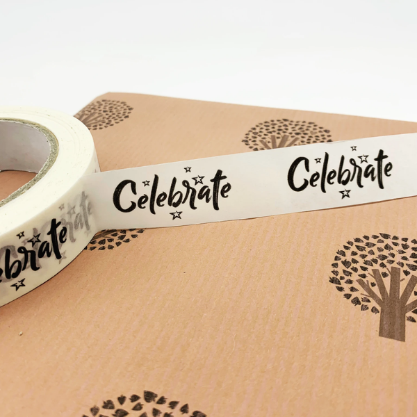 Eco-friendly paper tape (white) with text reading "Celebrate" in black font on a brown paper parcel